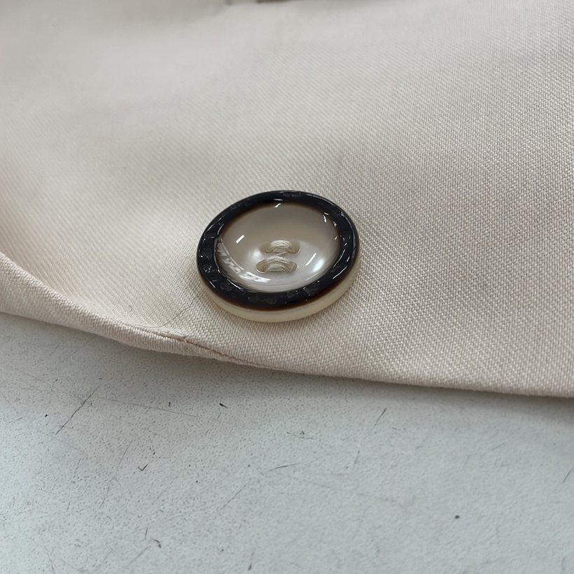 Detalhe de acabamento: botão e gola do blazer